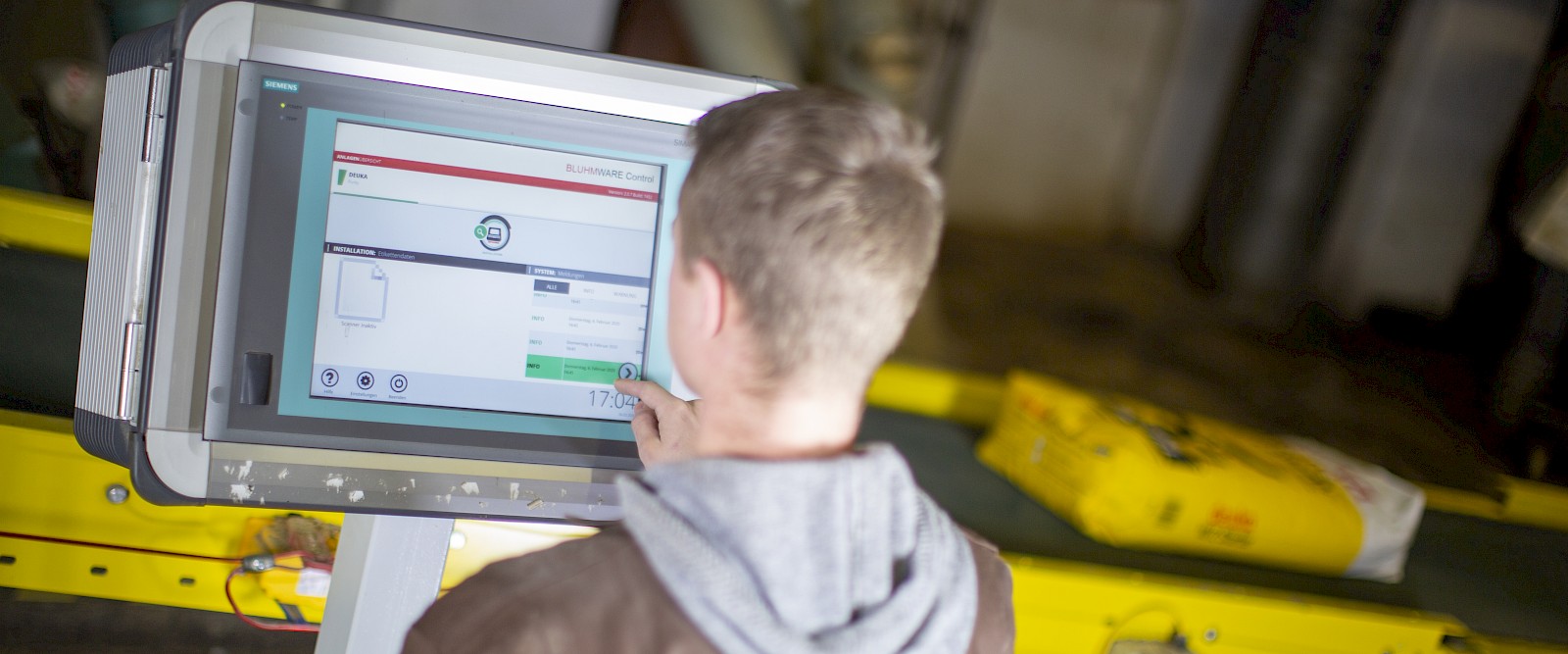 Tradesman operates computer in the bagging plant