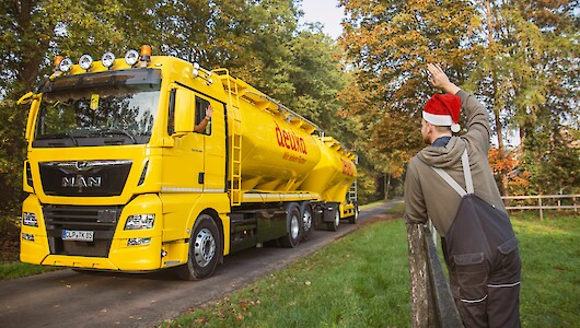 Landwirt mit Weihnachtsmannmütze winkt deuka-LKW (© deuka Tiernahrung Cremer).